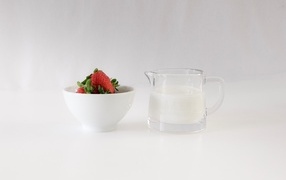 Красная клубника на столе с молоком