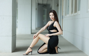 Девушка азиатка в черном наряде позирует для фото