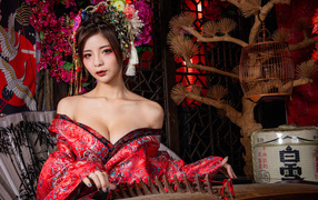 Милая девушка азиатка в красном кимоно с инструментом в руках