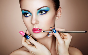 Девушке делают красивый яркий макияж