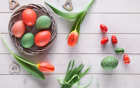 Красивые яйца с тюльпанами на белом столе на Пасху