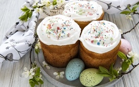 Три пасхальных кулича с яйцами на тарелке