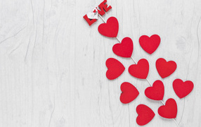 Много красных сердечек с палочкой на белом столе