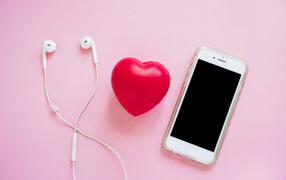 Телефон, наушники и красное сердце на розовом фоне