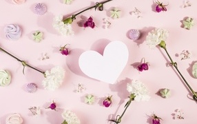 Белое бумажное сердце на розовом фоне с цветами