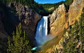 Водопад стекает по крутому склону скалы летом