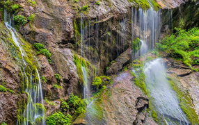 Водопад стекает по большим холодным камнях