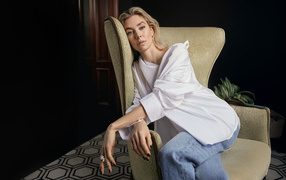 Актриса Ванесса Кирби в белой рубашке сидит на кресле