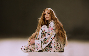 Популярная актриса Линдси Лохан в платье сидит на полу