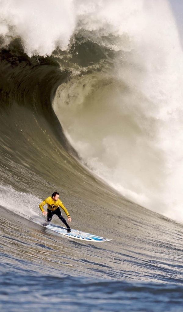 Серфер спускается с волны
