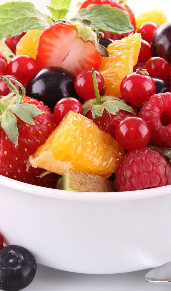 Салат из фруктов в белой чашке