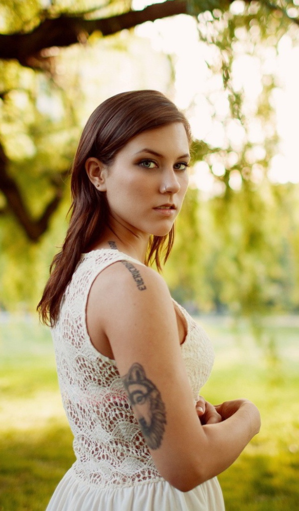 Брюнетка с татуировкой на природе