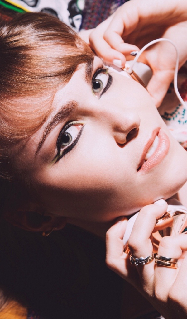 Девушка лежит с наушниками