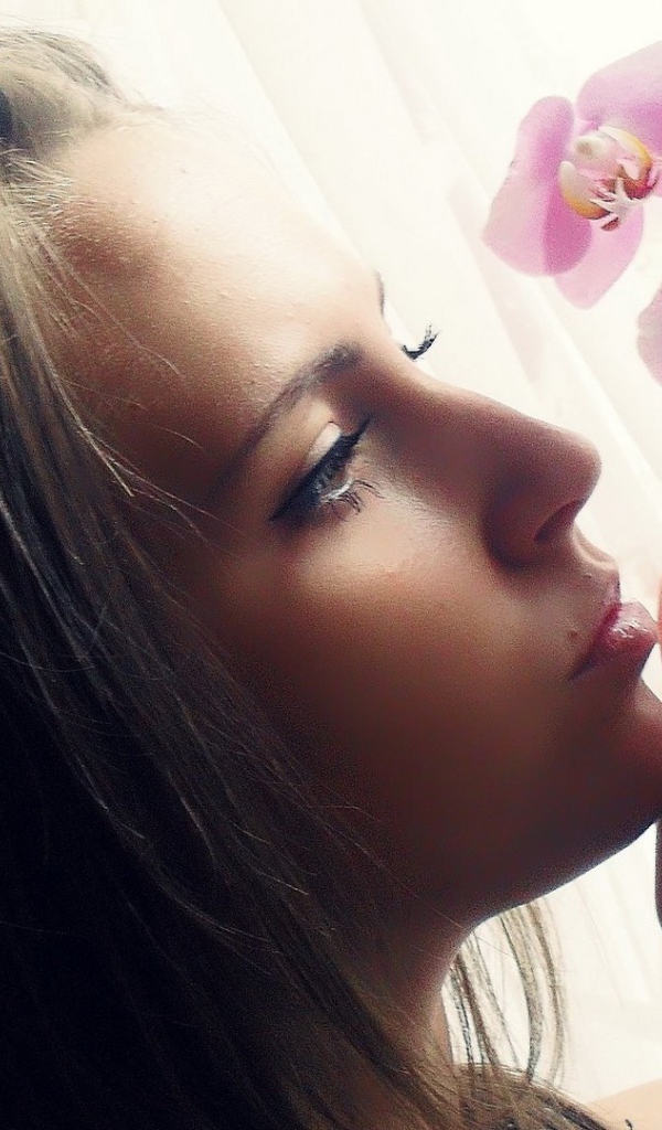 Девушка смотрит орхидею