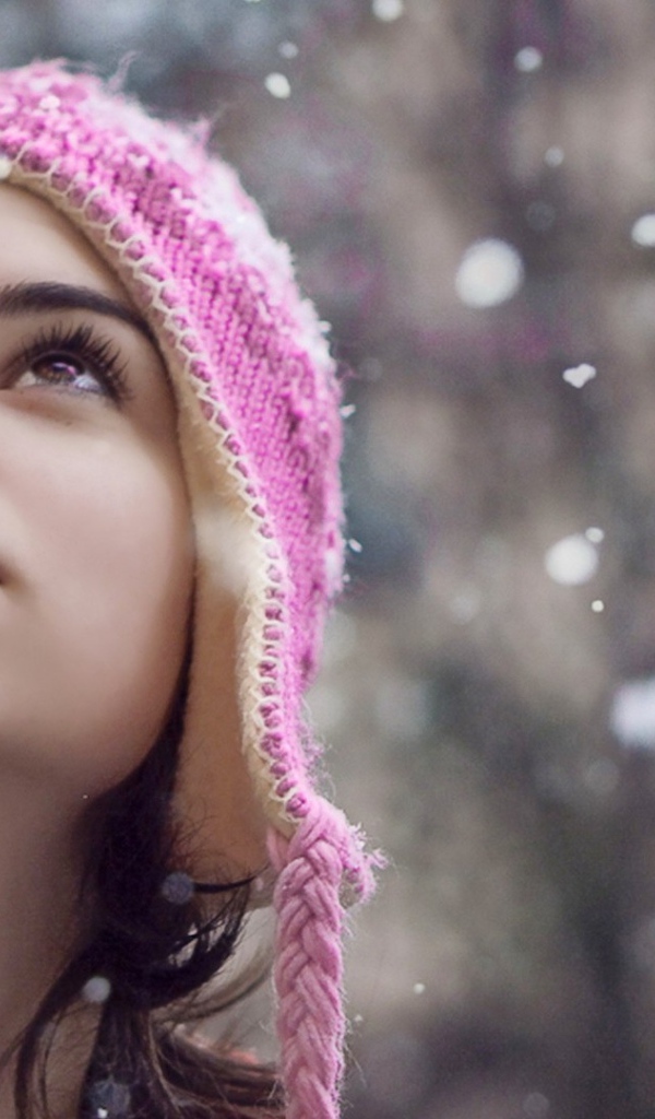 Девушка смотрит на падающий снег