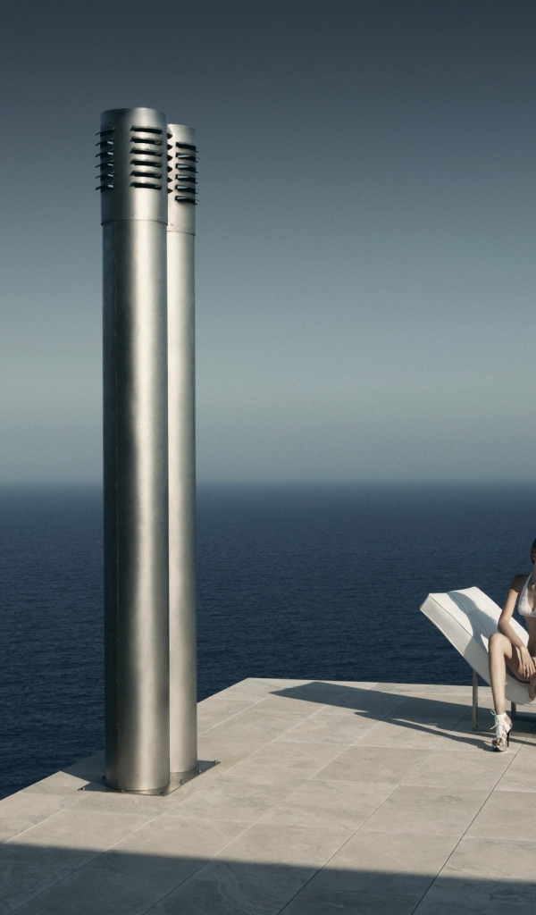 Девушка сидит у моря