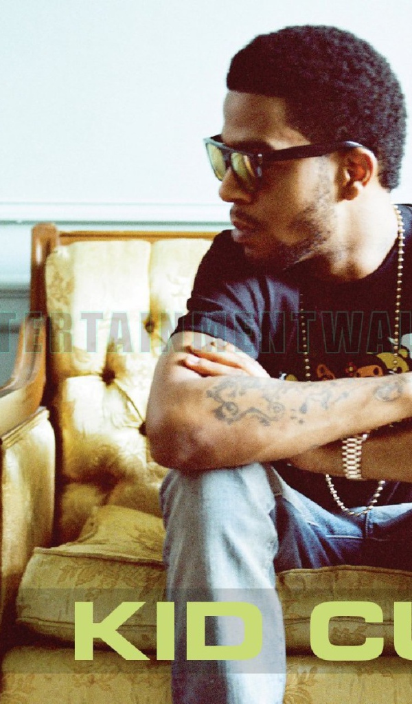 Kid Cudi сидит на желтом диване