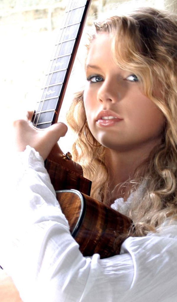 Taylor Swift обнимает свою гитару
