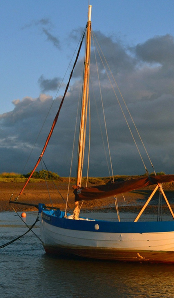 Парусная лодка стоит у берега