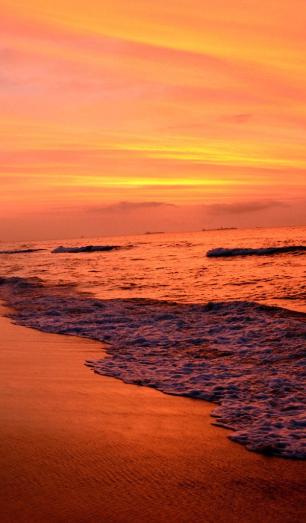 На закате волны лижут пляж