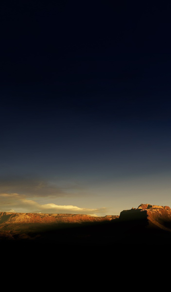 Солнце на закате освещает гору