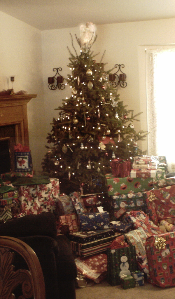 Много подарков под новогодней елкои