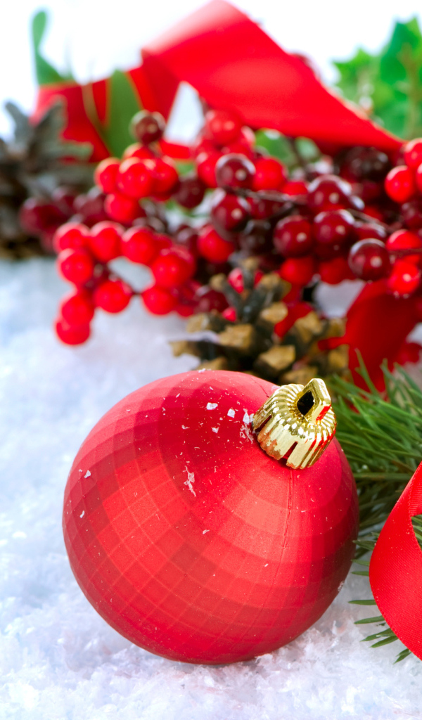 Красные ёлочные украшения на снегу