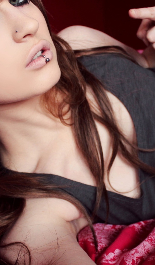 Красивая девушка шатенка с пирсингом в носу и губе