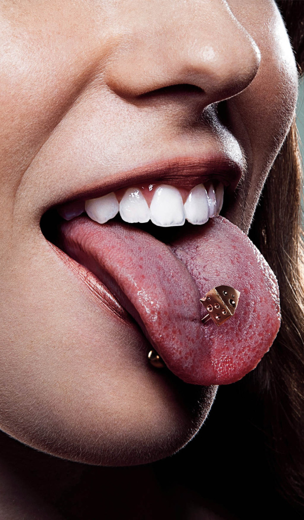 Девушка брюнетка с пирсингом в языке