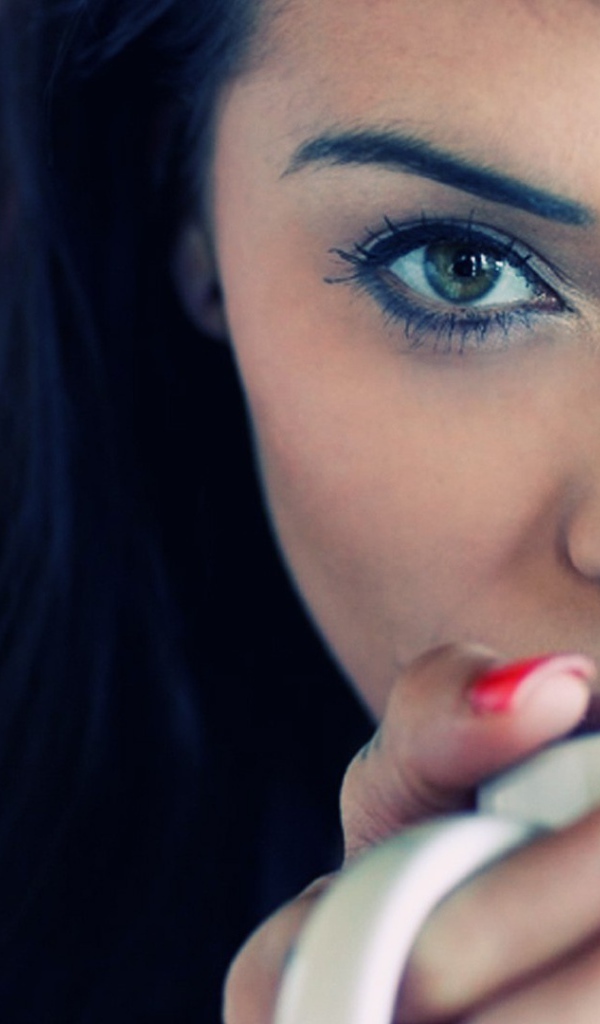 Девушка брюнетка с пирсингом в носу и красными ногтями