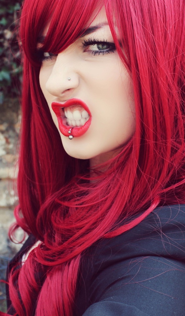 Девушка с красными волосам и пирсингом в носу и губе