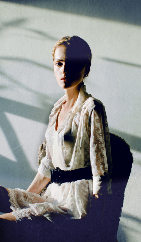 Фотография девушки на фоне белой стены