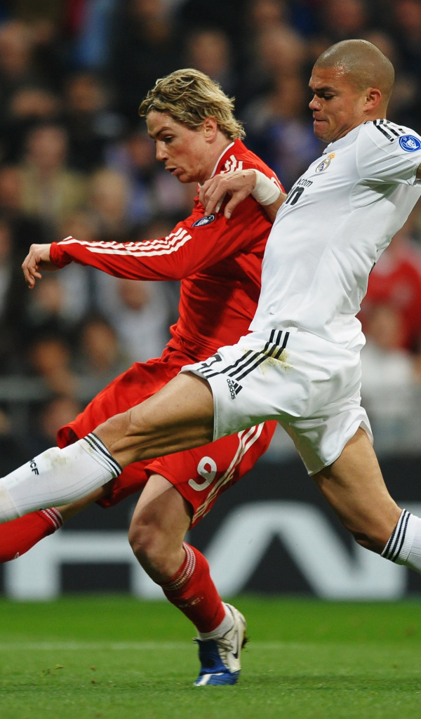 Игрок из Реал Мадрид Пепе пытается взять мяч