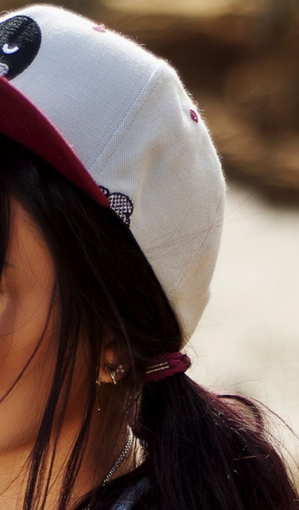 Девушка брюнетка в кепке и с пирсингом в носу