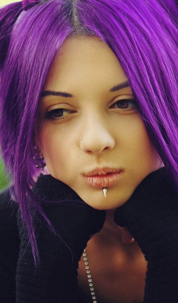 Молодая девушка с пирсингом в носу и губах