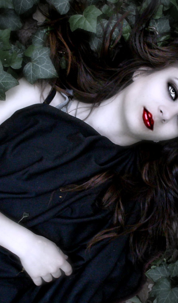 Девушка вампир лежит в листьях