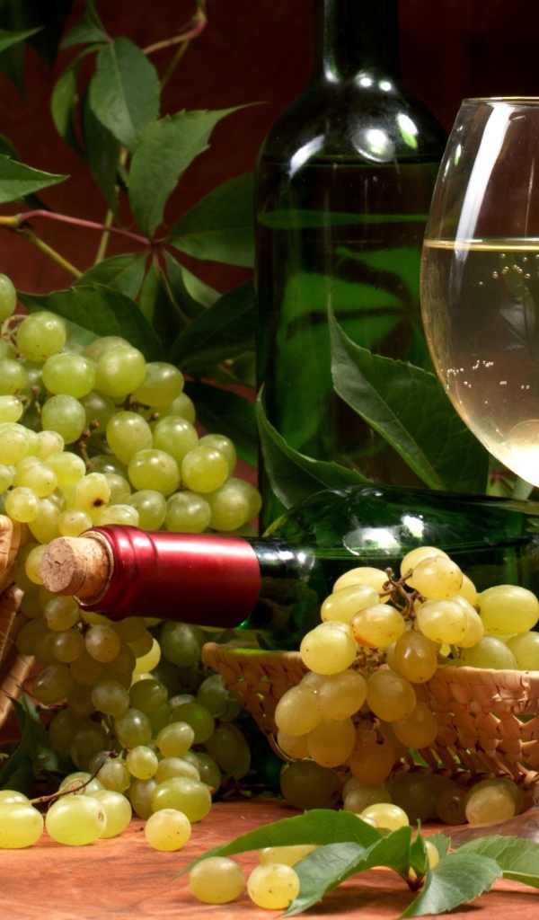 Белое вино и гроздья винограда