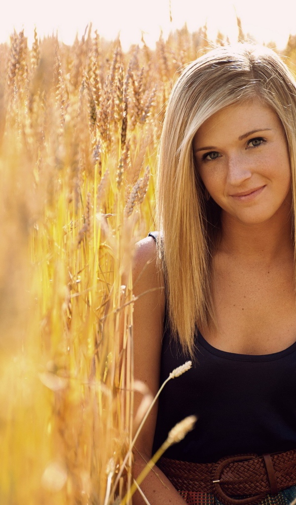 Девушка с веснушками среди пшеницы