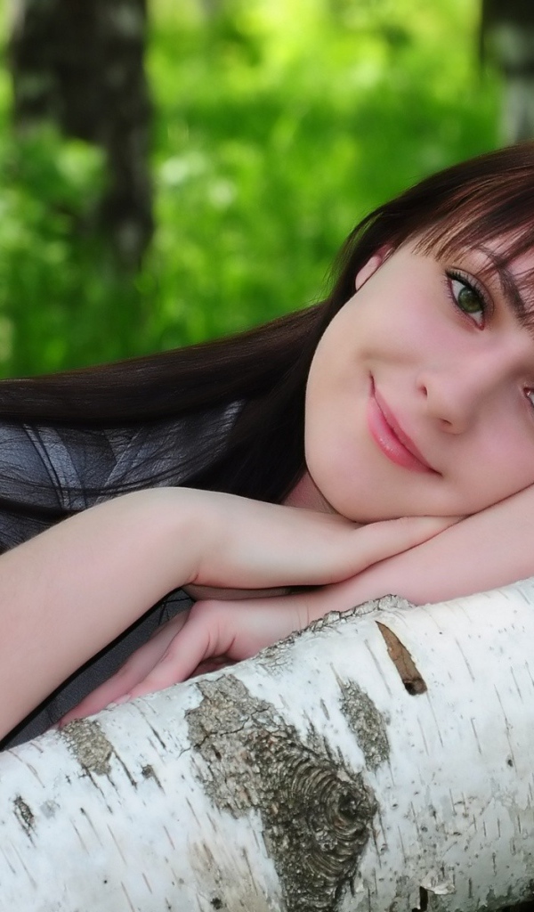 Девушка улыбается в лесу