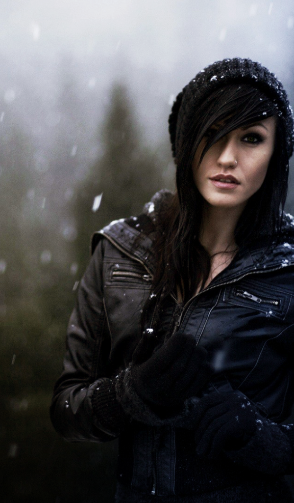 Брюнетка в куртке под снегом