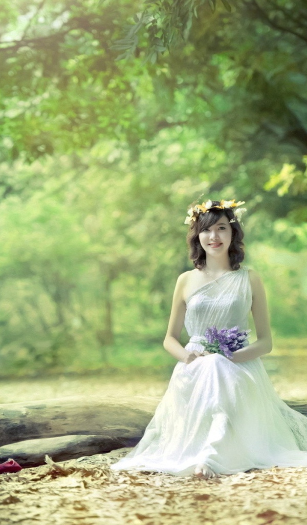 Девушка сидит на бревне