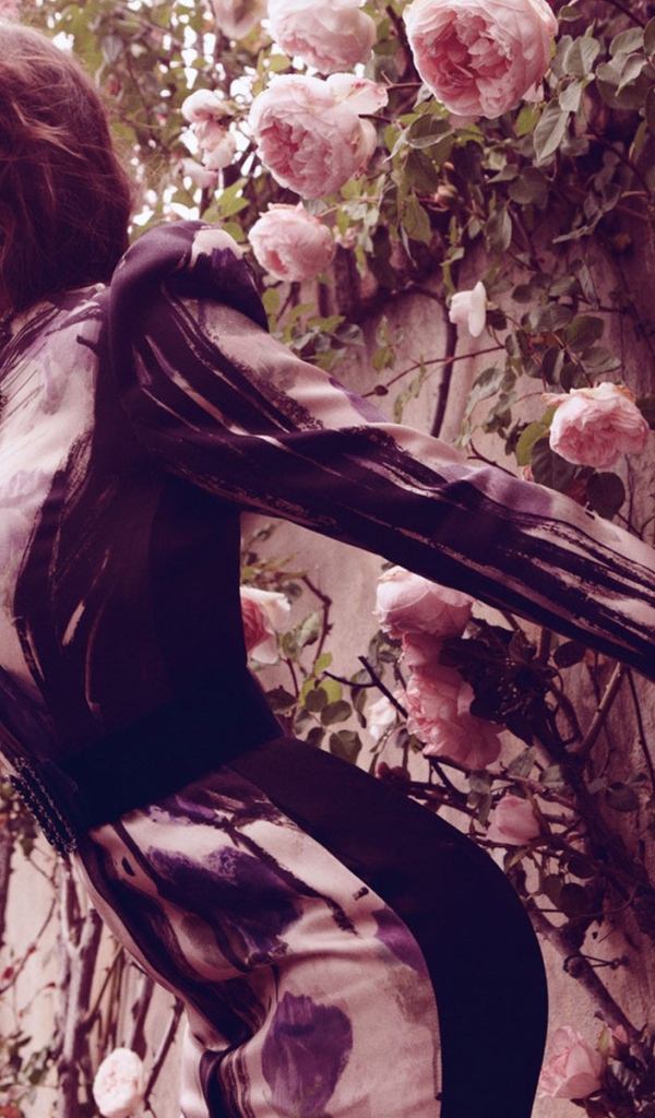 Джессика у стены с цветами