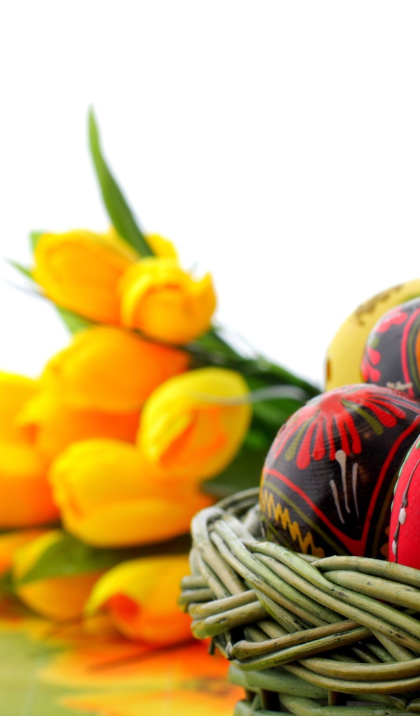 Корзина яиц на фоне тюльпанов на Пасху