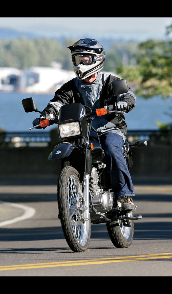 Новый мотоцикл на дороге Suzuki DR 200 SE