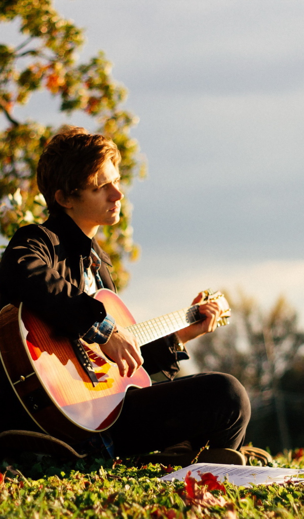 Парень с гитарой у дерева