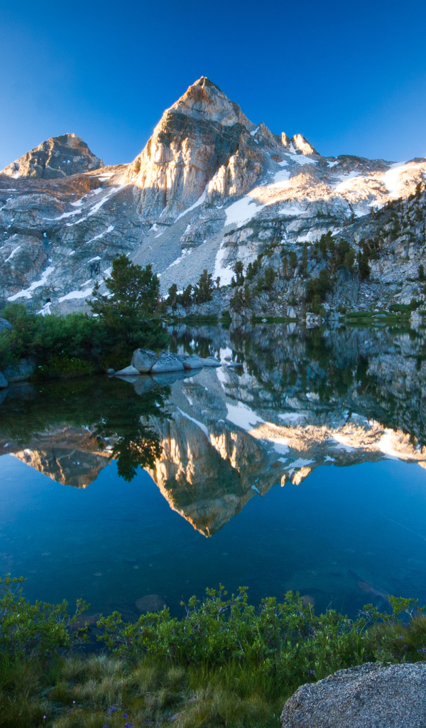 Горы отражаются в воде озера