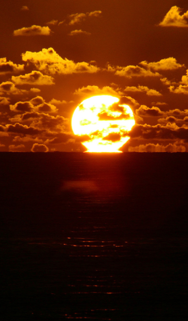 Солнце между небом и морем