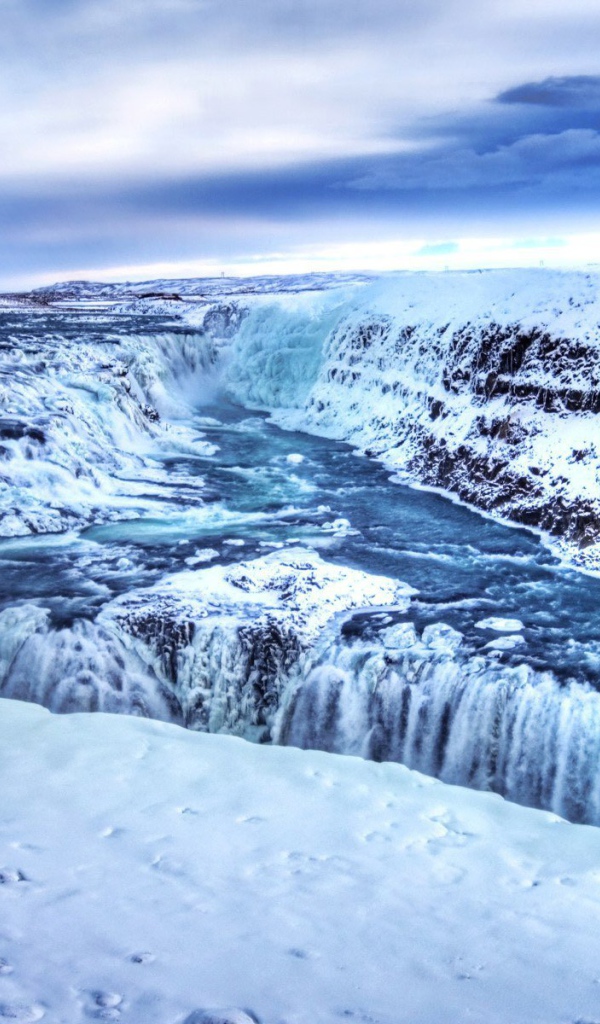 Замерзший водопад среди горных вершин