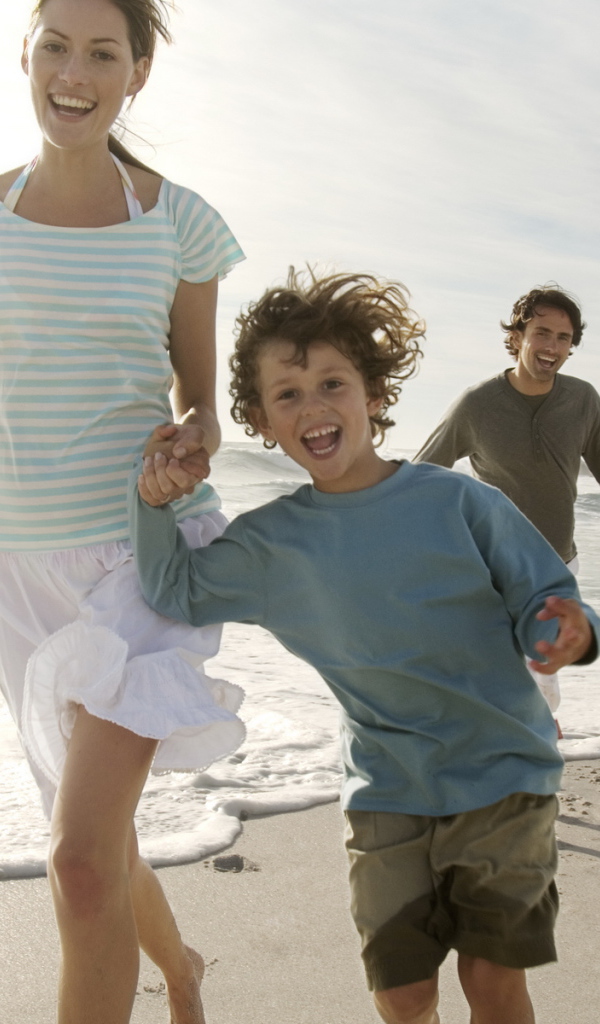 Семья гуляет на пляже