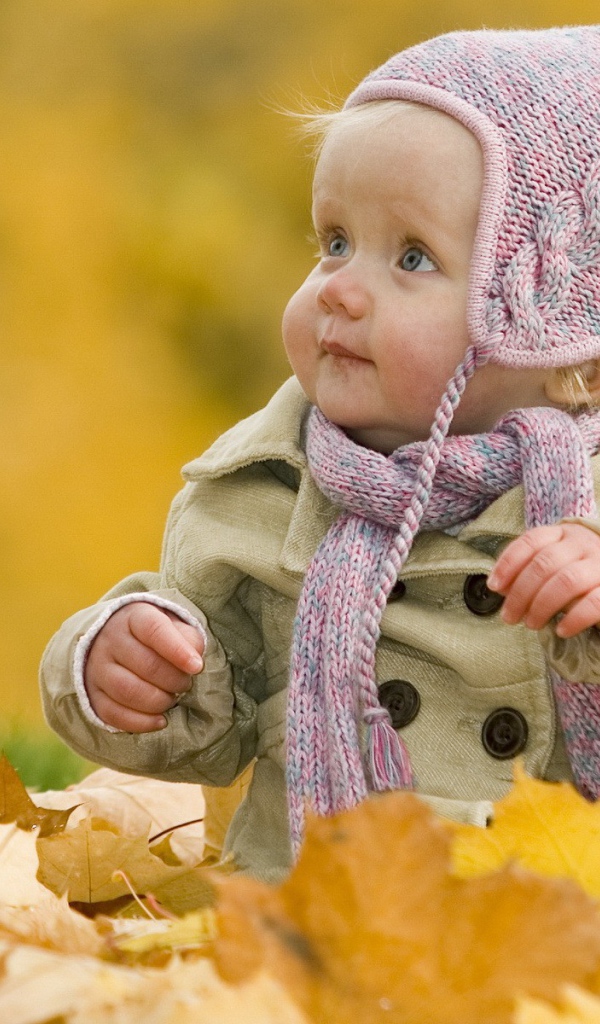 Ребенок играет осенними листьями